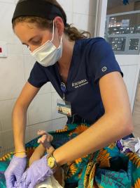 Nursing student covering newborn manikin in local cloth